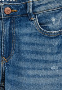 Blugi din denim albastru, prim-plan cu buzunar frontal, buclă pentru curea, nasture de cupru inscripționat "Blue Ridge" și detalii ușor uzate ale țesăturii.