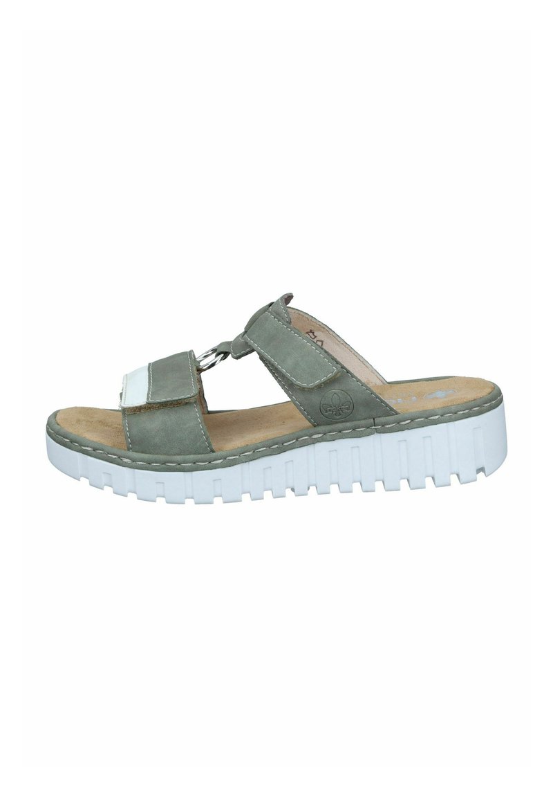 Sandalo scivoloso verde in suede con suola spessa bianca, dotato di una fascia e un accent metallico a forma di anello. La soletta soffice offre comfort.