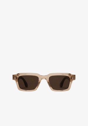 Lunettes de soleil transparentes beige avec des montures carrées et des verres brun foncé. Les caractéristiques incluent de subtils accents latéraux et une finition lisse et brillante.