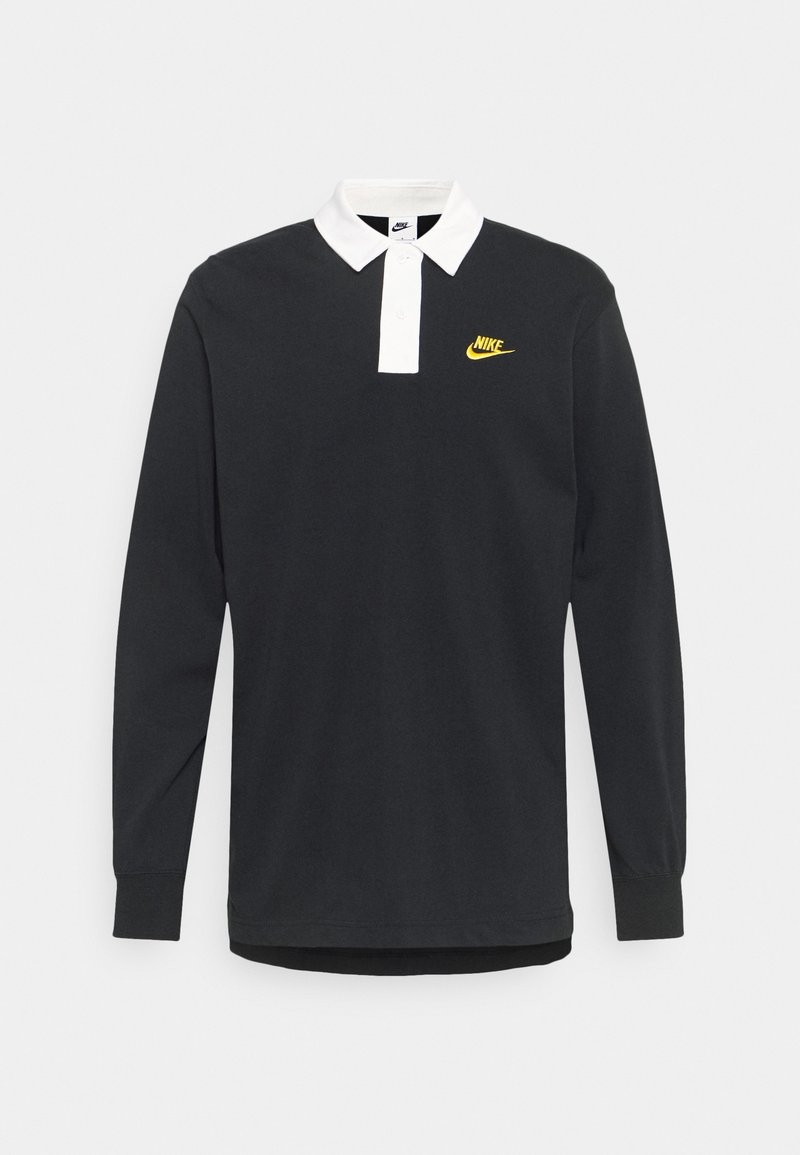 Polo de manga larga negro con cuello blanco y tapeta de botones, que presenta un pequeño logo de Nike en amarillo en el lado izquierdo del pecho.