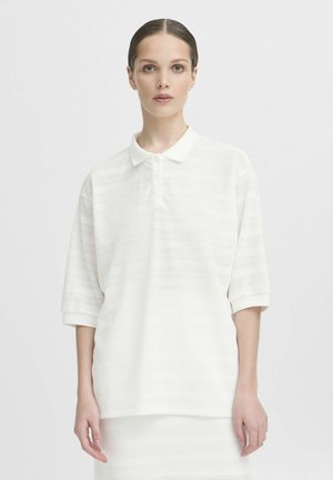 Witte polo met korte mouwen en een gestructureerd patroon, voorzien van een drieknops sluiting. Zachte stof met een lichte glans, met ribgebreide manchetten.