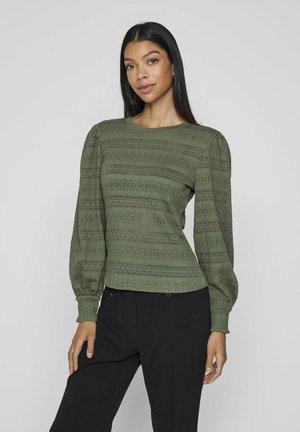 Green textured blouse with long puff sleeves, featuring a pattern of horizontal stripes. Worn with black tailored pants, round neckline.