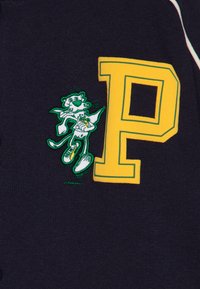 Navy blue cotton jacket featuring a large yellow "P" and a cartoon character in green embroidery holding a banana.