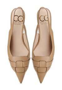 Tacchi slingback in pelle beige con punta appuntita, caratterizzati da un accento annodato sulla tomaia e pannelli laterali ritagliati. Logo dorato all'interno.