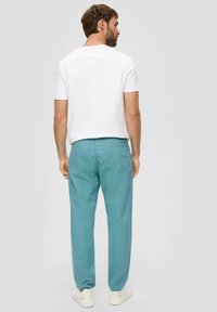 Lichtblauwe casual broek van lichtgewicht stof, met een rechte pasvorm, zij- en achterzakken, gecombineerd met een wit T-shirt.