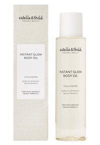 Bottiglia di vetro trasparente con un tappo bianco, etichettata "Olio per il corpo Instant Glow." Accompagnata da una scatola beige con testo minimalista.