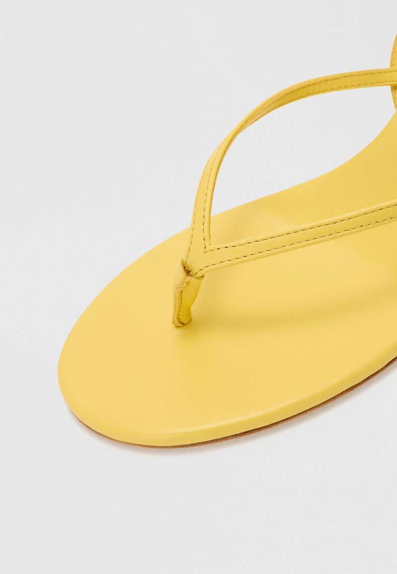 Yellow flip-flop sandal featuring a flat sole, thin straps, and a toe post. Smooth texture with minimalistic design and no visible hardware.
