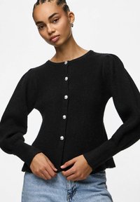 Czarny sweter z dzianiny, z okrągłym dekoltem, długimi bufkami oraz sześcioma srebrnymi guzikami z przodu. Teksturowana tkanina o dopasowanym kroju.
