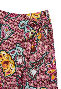 La gonna avvolgente a fiori presenta uno sfondo rosa con grandi motivi floreali multicolori, arricchiti da dettagli verdi, marroni e gialli.