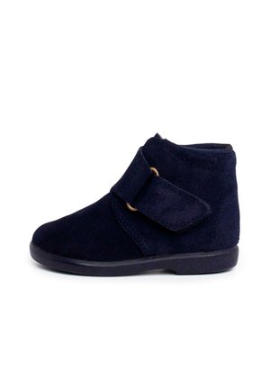 Marineblauer Wildlederstiefel mit abgerundeter Zehenpartie, Knöchelhöhe und verstellbarem Klettverschluss. Matt schwarze Sohle und minimale Nähdetails.
