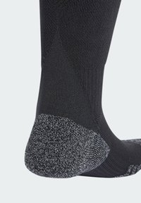 Calcetín negro con una parte superior de punto negro texturizado y área de talón y punta reforzada en gris oscuro contrastante para mayor durabilidad.