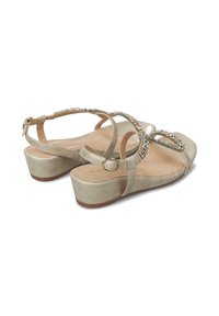 Sandalias de cuña de ante beige con una correa decorativa de piedras preciosas, correa ajustable en el tobillo y una suela texturizada para un mejor agarre.