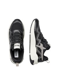 Sneaker atletiche nere e grigie con tomaia imbottita, sovrapposizioni testurizzate, cuciture a contrasto e suole bianche. Chiusura con lacci e dettaglio del logo.