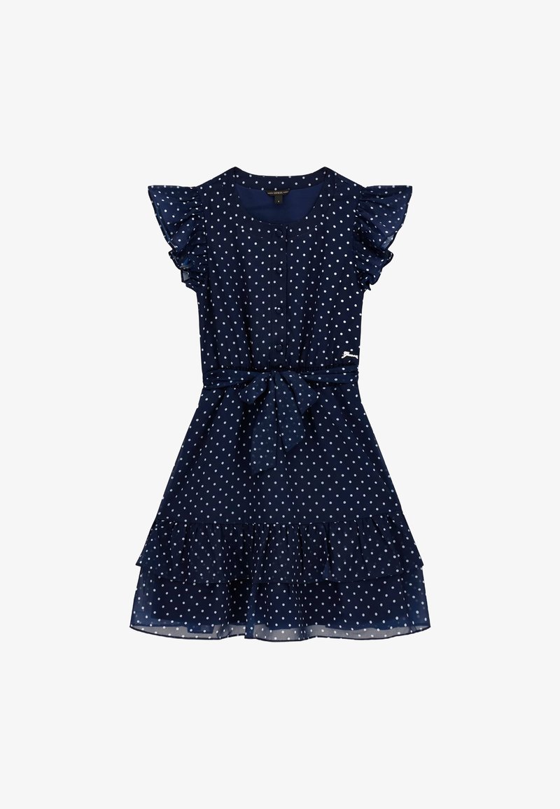 Tumši zila kleita ar punktiņiem, īsām volānu piedurknēm, saišu jostu un vairākiem volānu līmeņiem apakšmalā. Izgatavota no viegla, plūstoša auduma.