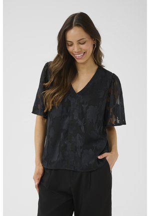 Black blouse with short, sheer sleeves and V-neck, featuring a floral pattern. Fabric has a textured, lightweight appearance.