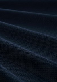 Țesătură texturată de culoare bleumarin cu un model discret în diamant, având pliuri drapate care evidențiază flexibilitatea și profunzimea sa.