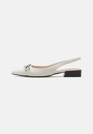 Valkoiset nahkaiset slingback-kengät, joissa on terävä kärki, litteä korko ja koristeellinen hopeinen solki yläosassa.