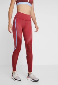 Røde atletiske leggings med høj talje, blå sidde accenter og mesh-detaljer. Materialet er glat, strækbart og tætsiddende til aktivt brug.