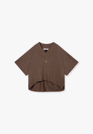 Haut marron à manches courtes avec encolure en V, coupe ample, ourlet asymétrique, et petit anneau métallique au centre devant.