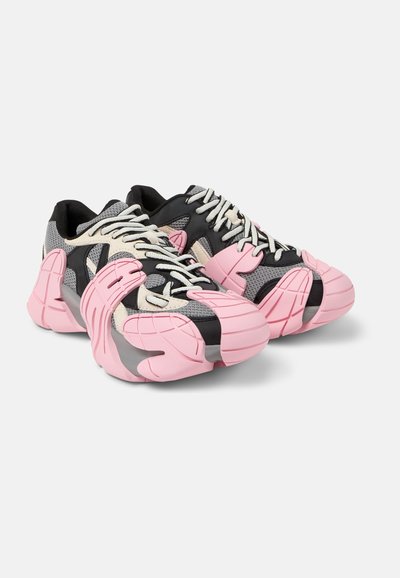 Sport sneakers featuring a black mesh upper with pink and cream accents. Thick rubber soles and distinctive sculpted design elements.