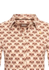 Langarmshirt van gemusterde stof, met een beige achtergrond en kastanjebruine bladontwerpen, en een merklabel onder de kraag.