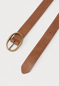 Καφέ δερμάτινη ζώνη με υφή στην επιφάνεια, με οβάλ χάλκινη αγκράφα και πολλαπλές οπές για ρύθμιση μεγέθους.