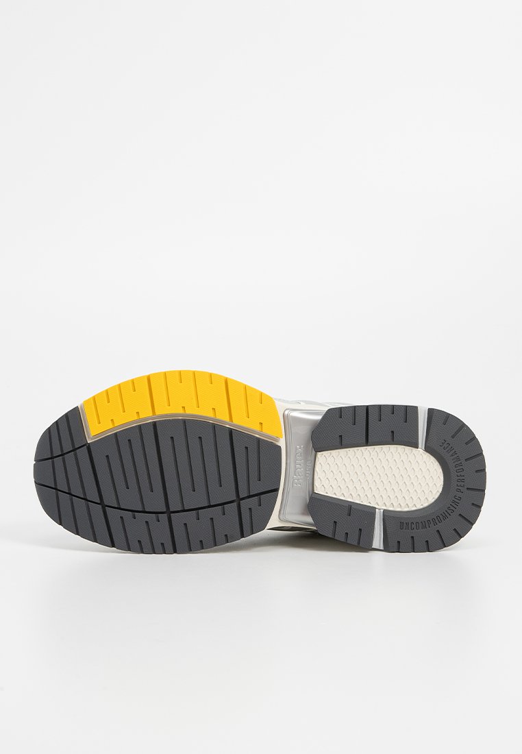 Suola della scarpa con un design multicolore, gomma grigia, accenti gialli e pattern testurizzati per una maggiore aderenza.