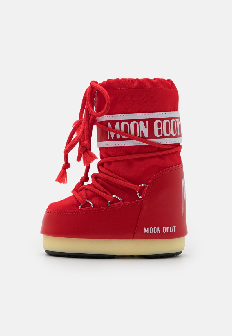 Röd Moon Boot med en övre del i tyg, rund tå och vadderad krage. Har snörning och ett vitt logoband. Tjock gummisula med svart mönster.