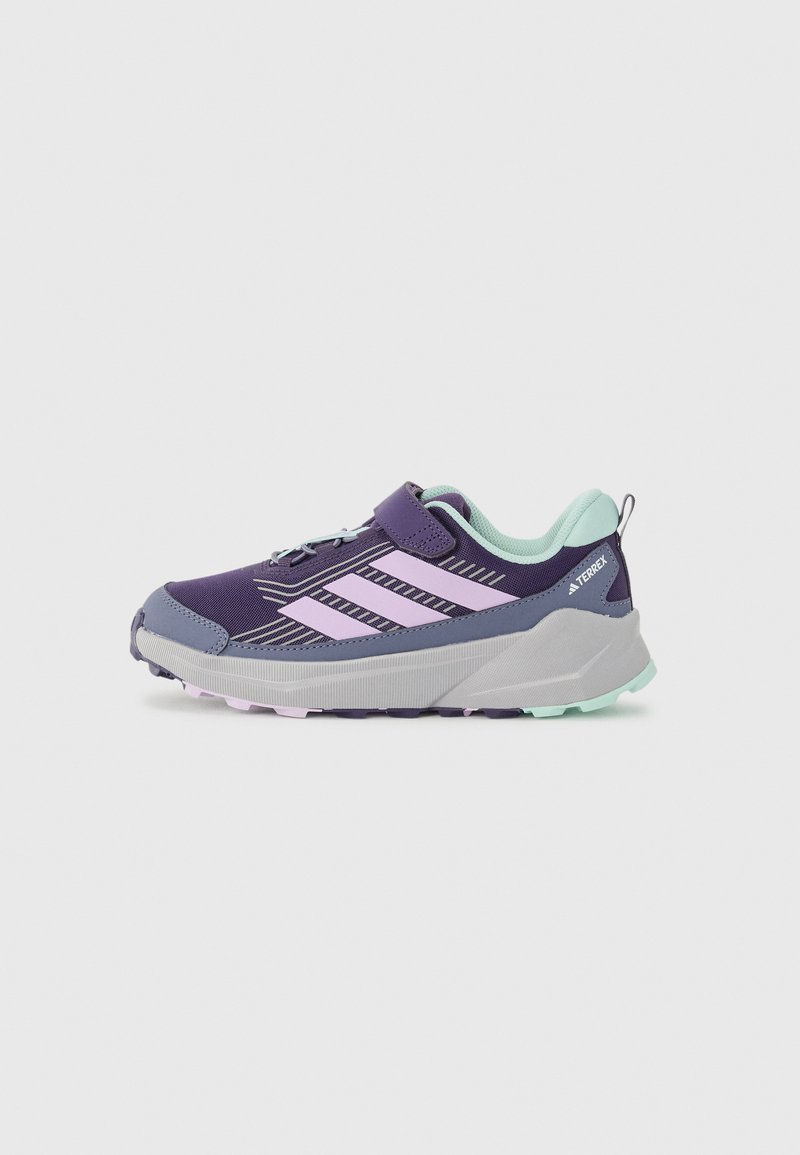 Chaussure de sport violette avec une tige en maille, présentant des rayures roses, un col en menthe douce et une semelle grise épaisse. Conçue pour une activité en plein air.