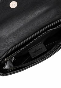 Black leather bag interior with zip closure, textured surface, and a brand tag visible. Features a smooth lining with organized pockets.
