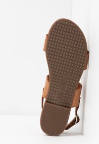 Semelle de sandale marron avec un motif de texture antidérapant, taille 37, et le nom de la marque Tamaris visible au bas.