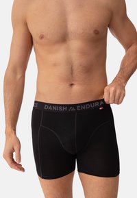 Boxer da uomo neri con un elastico morbido etichettato "DANISH ENDURANCE." Il tessuto è liscio con dettagli di cuciture a contrasto.
