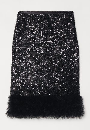 Falda lápiz negra de lentejuelas con un dobladillo de textura pelusa. Presenta una forma ajustada y una superficie brillante, creando un contraste llamativo en los materiales.