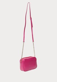 Borsa a tracolla in pelle rosa con forma rettangolare, dotata di catena e tracolla regolabile, accessori in oro e chiusura con zip.