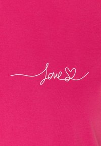 Pink cotton fabric featuring white cursive text reading "Love" with a heart accent, smooth texture and simple design.