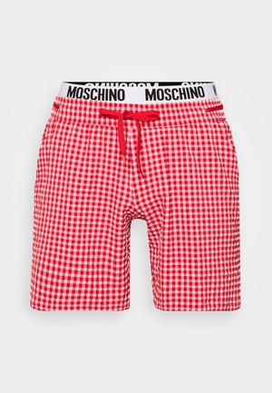 Červené a biele kratasy s kockovaným vzorom, ktoré majú elastický pás a sťahovaciu šnúrku. V oblasti pása sa nachádza kontrastné čierne logo.