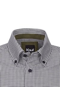 Camicia a quadretti bianca e nera in cotone. Presenta un colletto interno verde e un'etichetta prominente con il marchio "Kauf".