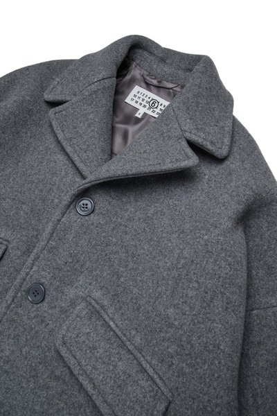 Szary wełniany płaszcz z klapami, dwoma guzikami i teksturowanym wykończeniem. Posiada gładką satynową podszewkę oraz dwie przednie kieszenie.