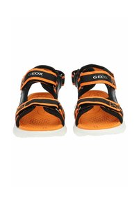 Černé a oranžové sandály s nastavovacími popruhy, texturovanými oranžovými stélkami a bílou podešví. Na popruzích se nachází logo GEOX.