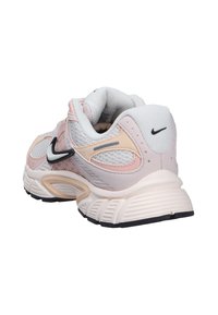 White and light pink Nike running shoe with black swoosh logo, mesh panels, and cushioned sole shown from rear side angle.
