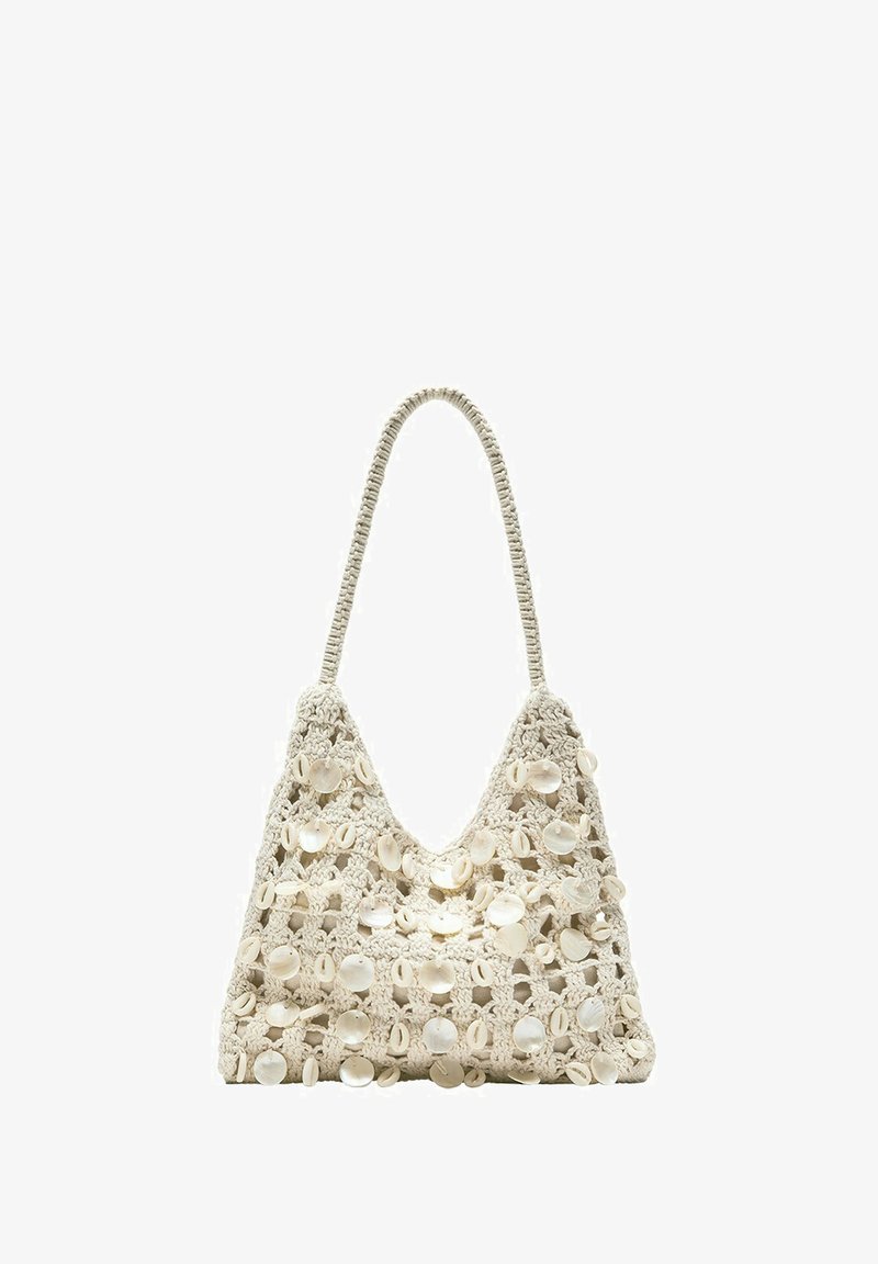Sac à épaule beige en crochet décoré de perles rondes blanches en coquillage, avec une poignée en boucle unique et un tissage ouvert.