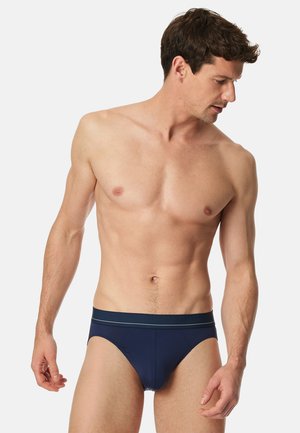 Boxers pour hommes de couleur bleu marine avec une texture lisse, une ceinture élastique ornée d'une subtile rayure et une coupe ajustée.