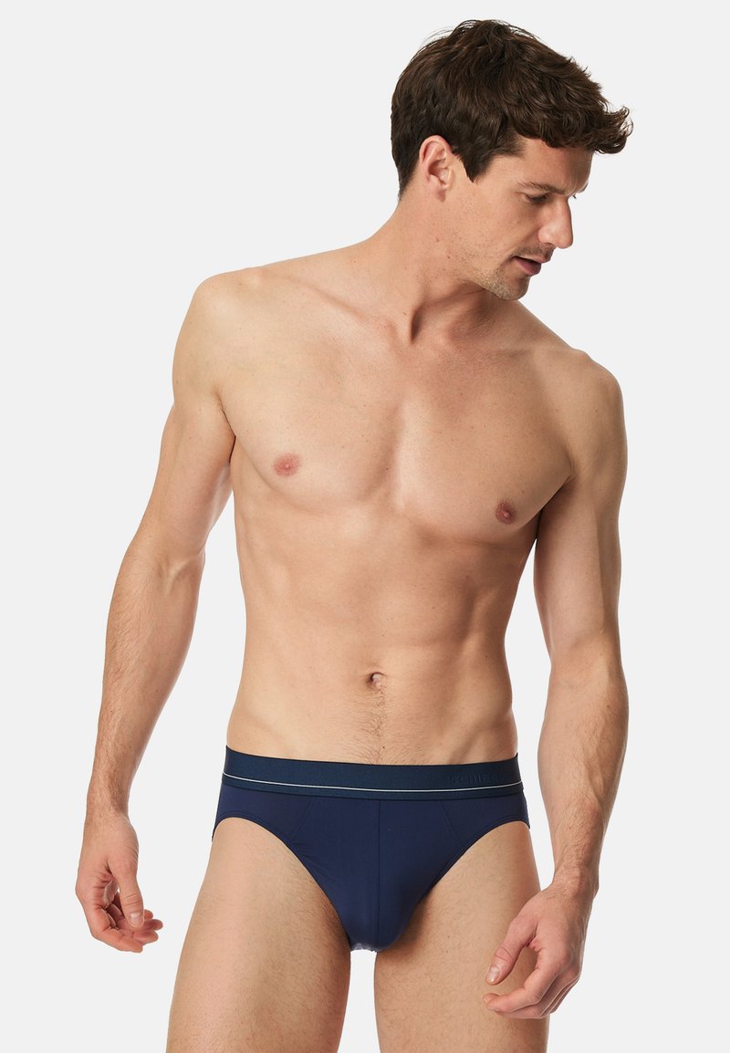 Marineblauwe herenboxershorts met een gladde textuur, een elastische tailleband met een subtiele streep en een aangesloten ontwerp.