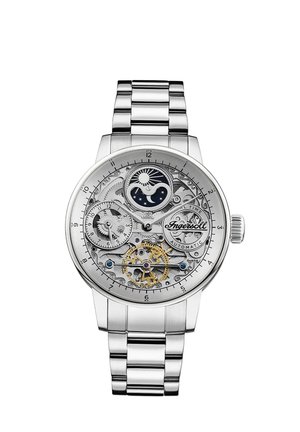 Montre automatique en acier inoxydable avec un cadran transparent, des rouages visibles, des accents dorés et un indicateur de phases lunaires sur fond argenté.