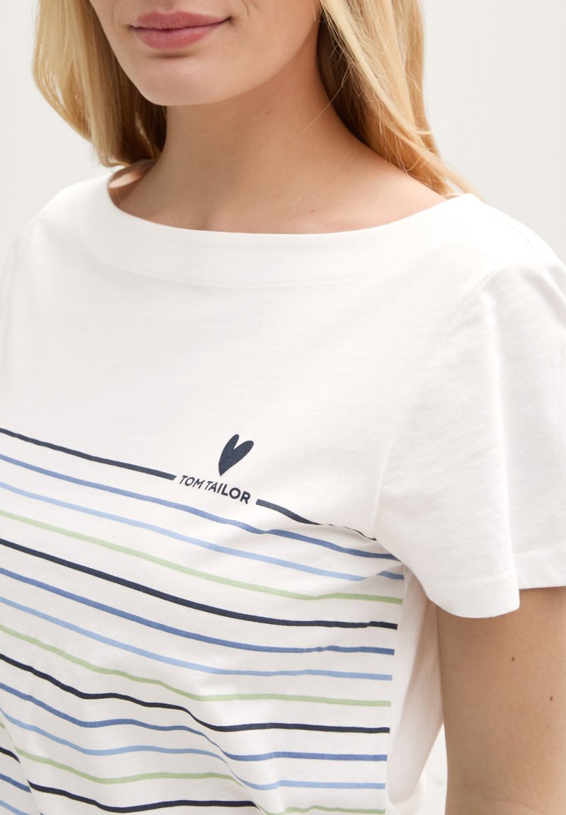 T-shirt blanc à encolure large, avec des rayures horizontales bleues, vertes et bleu marine. Petit logo "Tom Tailor" au-dessus des rayures.