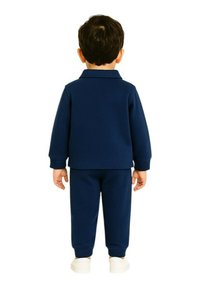 Survêtement bleu marine avec col ; manches longues et poignets élastiques. Matière douce, design uni, associé à des baskets blanches.