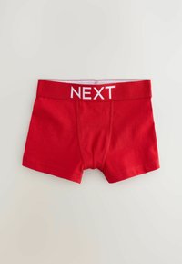 Röda bomullsboxershorts med ett vitt elastiskt midjeband där "NEXT" är tryckt med fet stil. Designen är enkel och har en mjuk textur.