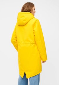 Gele waterdichte parka met een capuchon, voorzien van een getailleerde taille, lange mouwen en een lange achterkant. Gladde textuur en eenvoudig ontwerp.