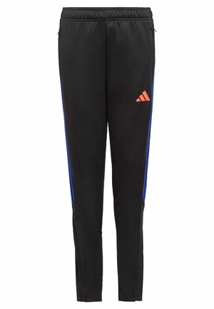 Pantaloni sportivi neri con vita elastica, strisce laterali blu, tasche con cerniera e piccolo logo Adidas arancione sulla coscia destra.