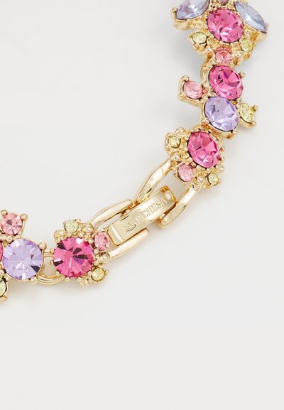 Armband in Goldton mit mehrfarbigen Strasssteinen in Pink, Violett und Grün, verbunden durch florale Akzente und einen detaillierten Verschluss.